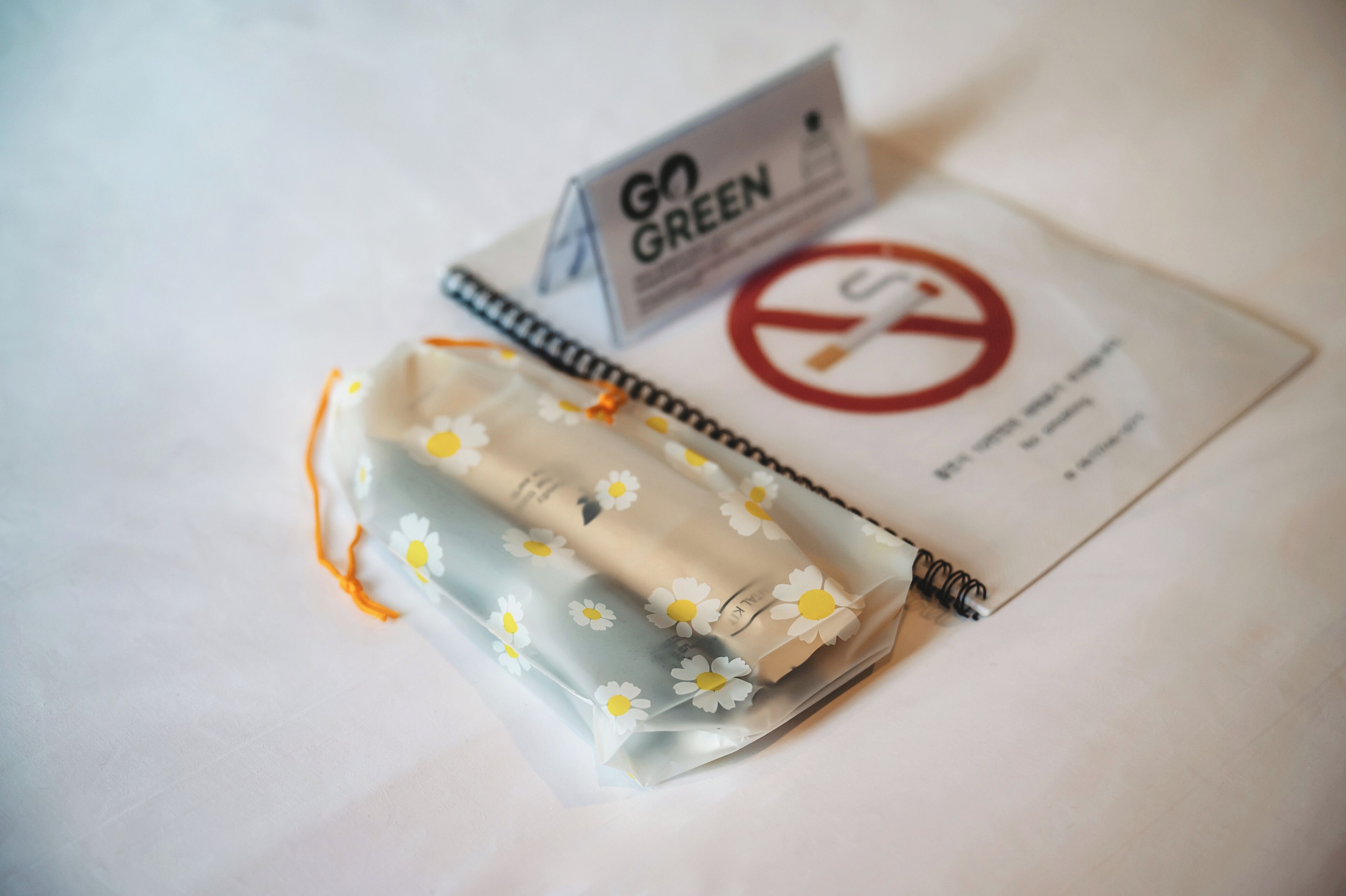 A notebook with a 'Go Green' label and a 'No Smoking' sign.