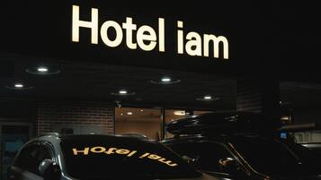 Ein Gebäude mit einem Schild, auf dem 'Hotel iam' steht, und mehreren Autos davor.