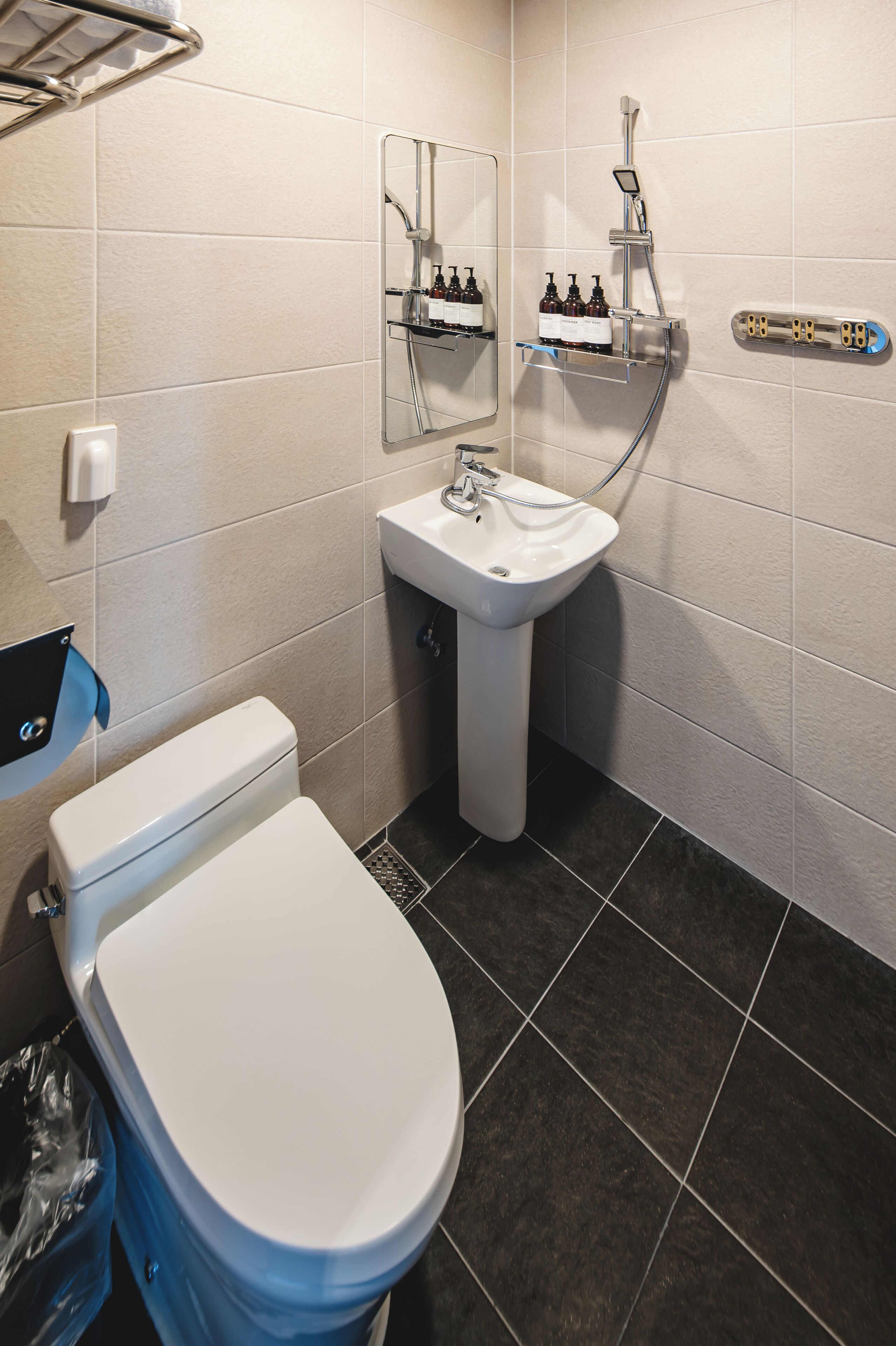 A bathroom with a toilet, sink, and shower.
