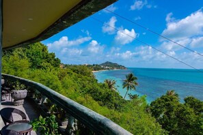 A balcony with outdoor furniture overlooking a coastal view. - Le Palais Hotel (Ko Pha-ngan)