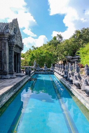 A pool with a stone balustrade and a temple-like structure on one side. - Le Palais Hotel (Ko Pha-ngan)