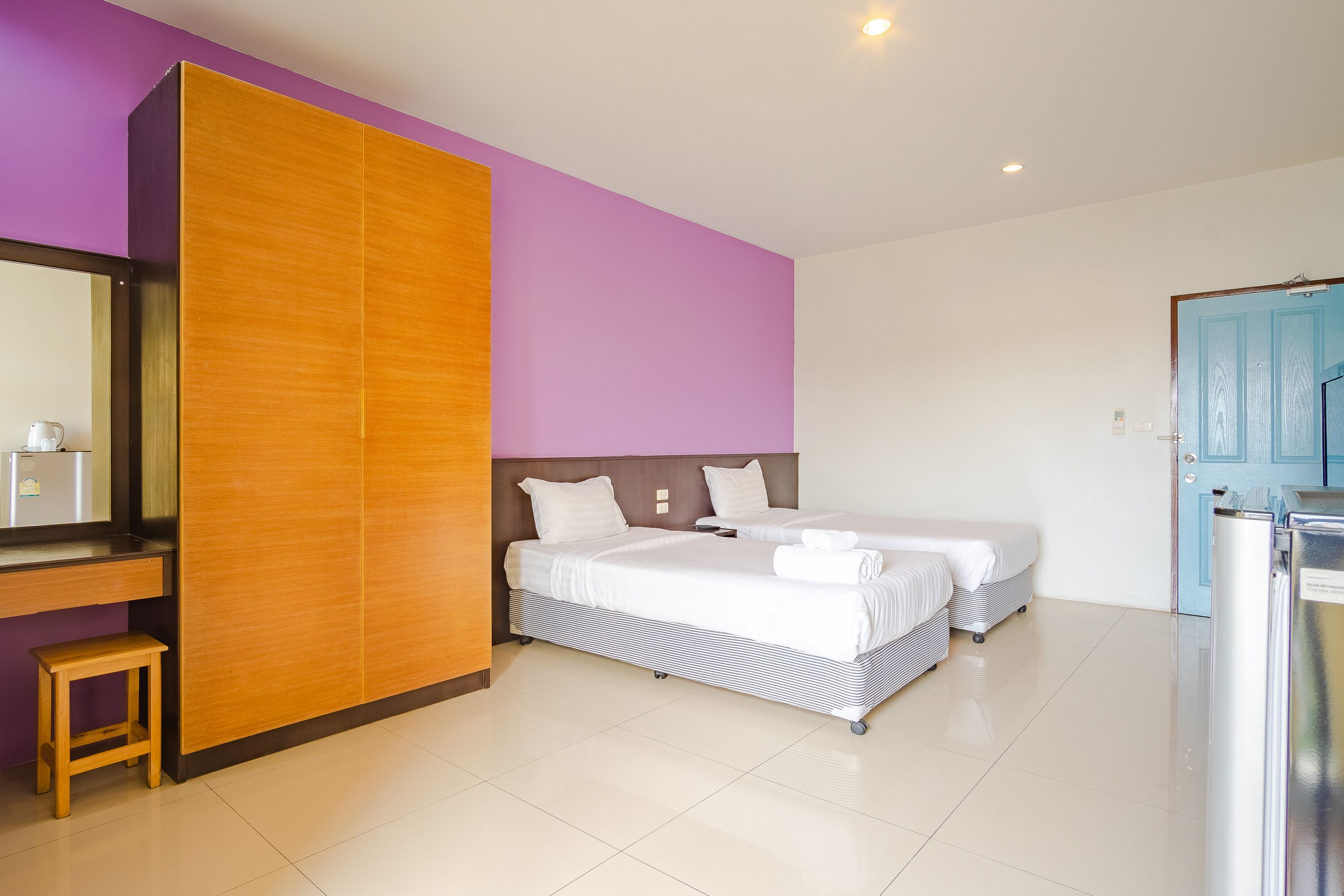 A hotel room with a bed, a desk, and a wardrobe.