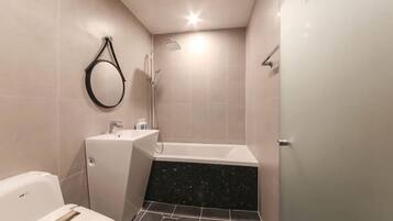 A modern bathroom with a toilet, sink, and bathtub.