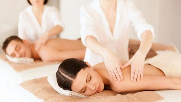En massagebehandling i en spa-miljö med en ren och minimalistisk inredning.