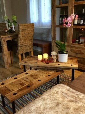 A wooden dining table with candles, a potted plant, and a bench. - Cottage on the lake with lake view (Neubäu am See/Roding)