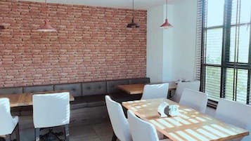 A modern interior with a brick wall, white furniture, and pendant lighting.
