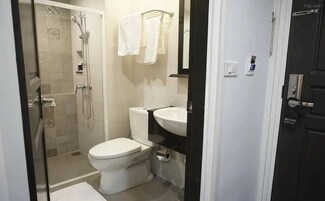 A bathroom with a shower, toilet, and sink.