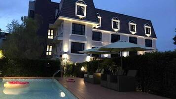 A two-story building with a swimming pool and outdoor seating.