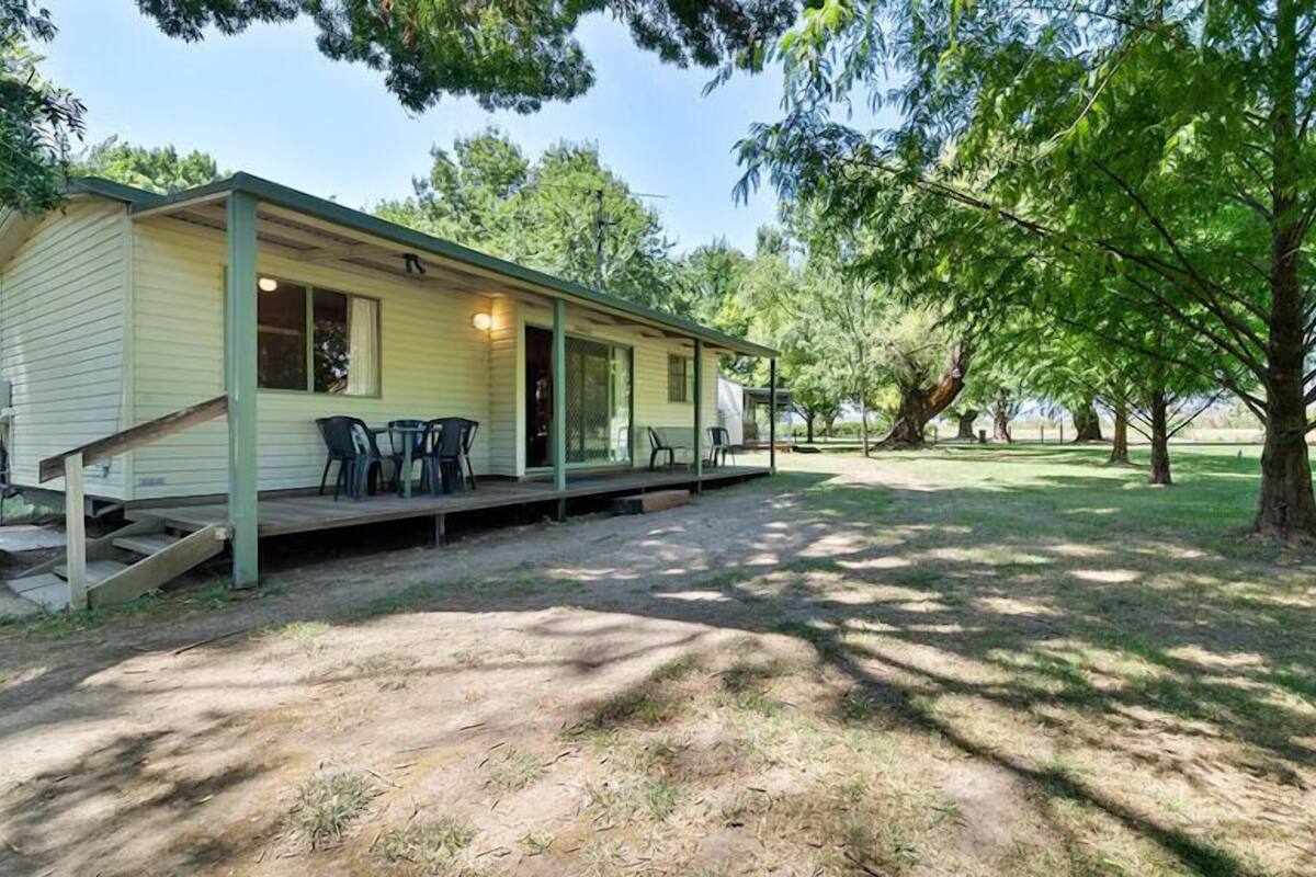 A single-story mobile home with a porch and outdoor seating area.