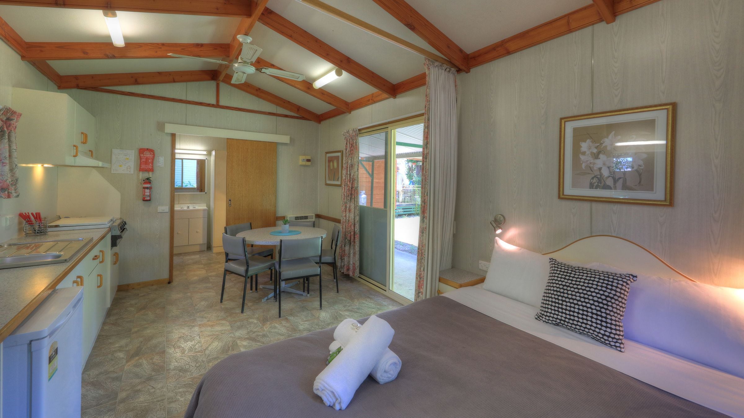 A cozy room with a bed, a dining area, and a kitchen.