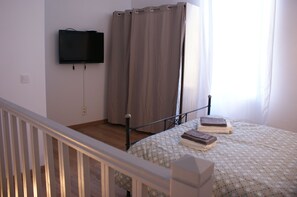 Relax in this cozy retreat with a single bed, TV, and balcony access.