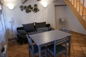 Cozy living space with a sofa, dining table, and staircase.