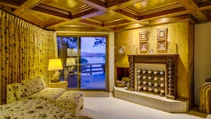 A cozy room with a bed, a fireplace, and a view of the outdoors.