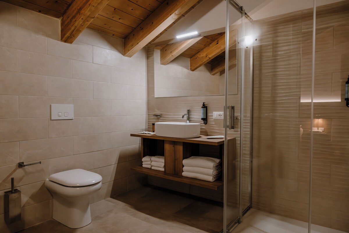 Un baño moderno con inodoro, lavabo y cabina de ducha de vidrio.