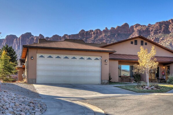 A single-story house with a garage, a patio, and a view of mountains.