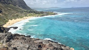 A coastal landscape with a beach, rocky shoreline, and distant mountains. - High Rise Deluxe Ocean View Free Parking/Wifi in Waikiki 3204 (Honolulu)