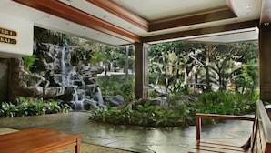 A room with a waterfall feature, a wooden bench, and a tiled floor. - High Rise Deluxe Ocean View Free Parking/Wifi in Waikiki 3204 (Honolulu)