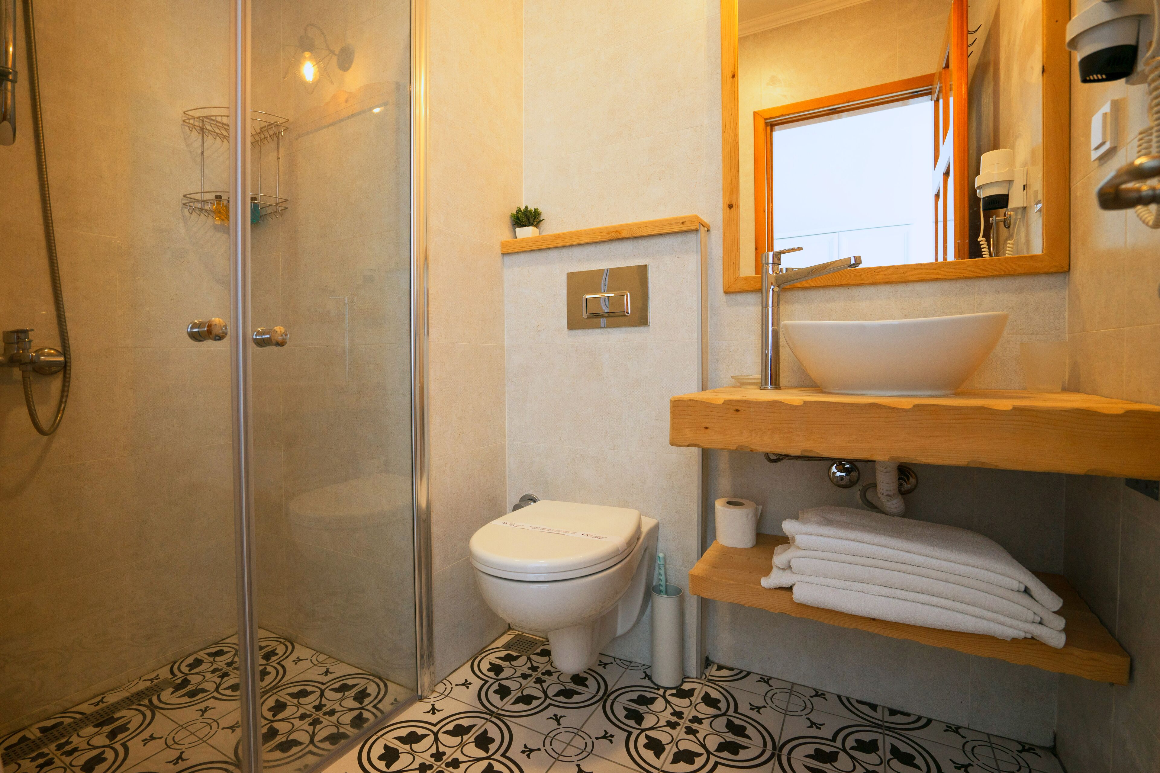 Un baño con ducha de vidrio, inodoro, lavamanos y espejo.
