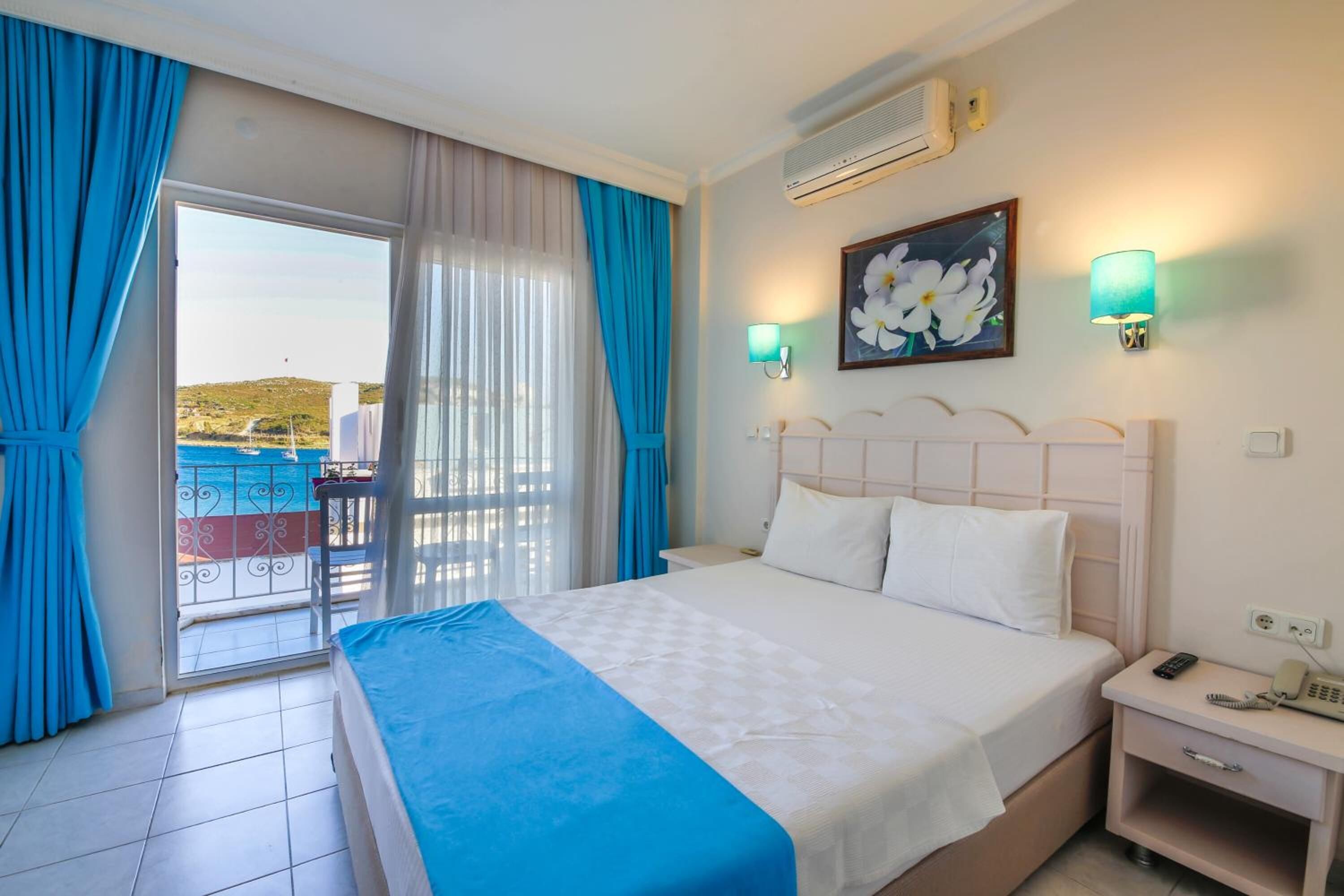 A hotel room with a bed, a nightstand, a phone, and a painting.