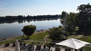 Vista de un lago con un pabellón, mesas de picnic y un muelle.