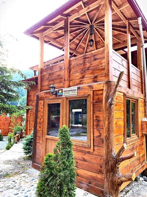 Une cabane en bois comprenant un espace d’accueil, une fenêtre où est affiché le menu et un petit sapin de Noël.
