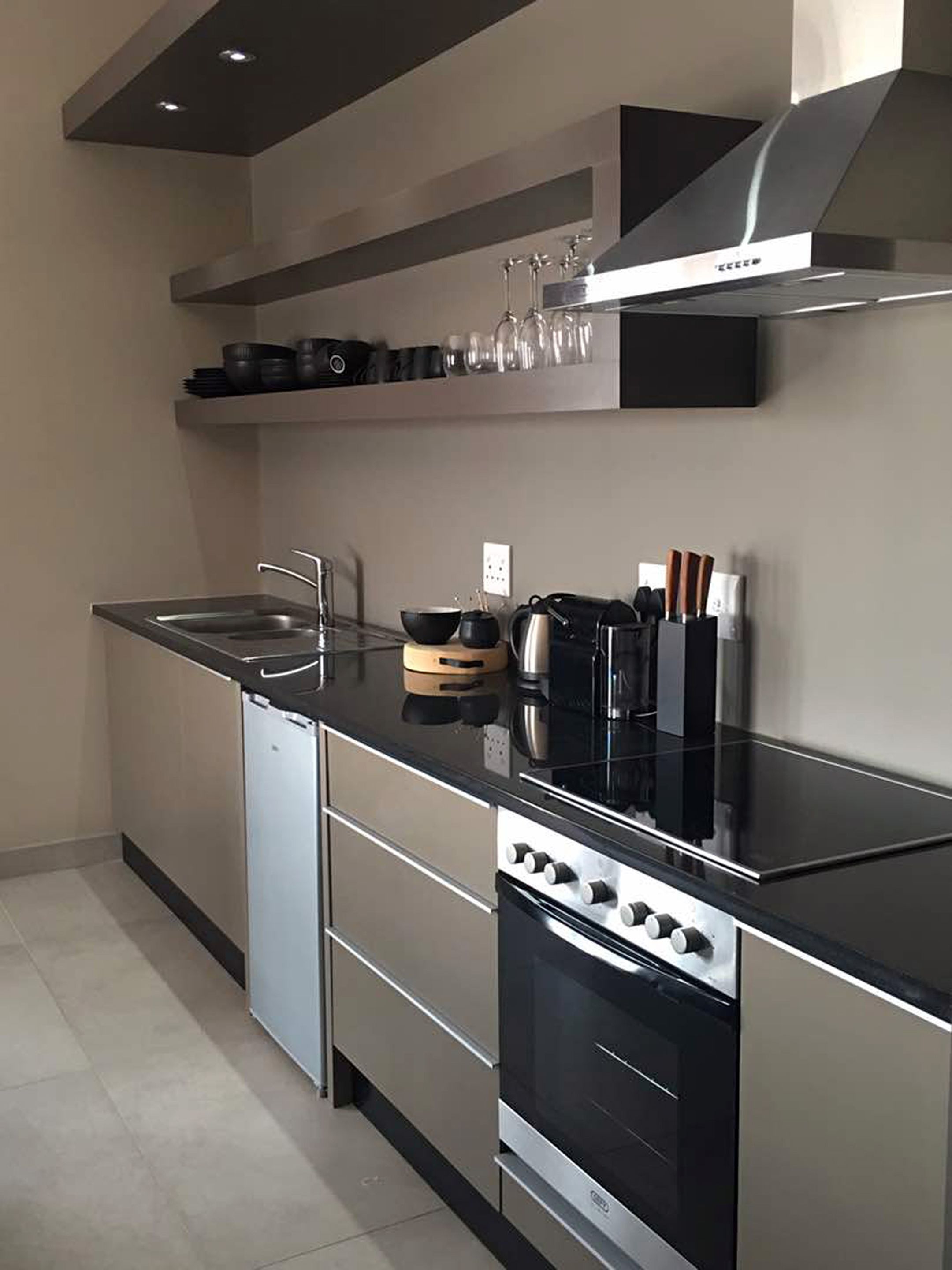 A modern kitchen with a black countertop, stainless steel appliances, and a built-in oven.