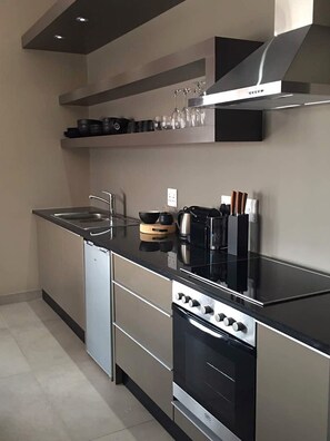 Departamento de lujo, 1 habitación, vista parcial al océano | Cocina privada | Refrigerador, horno, parrilla de estufa y cafetera de espresso 