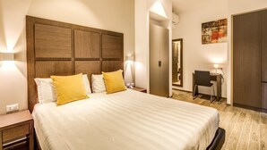 A hotel room with a large bed, a desk, and a wardrobe. - House Garden (Rome)