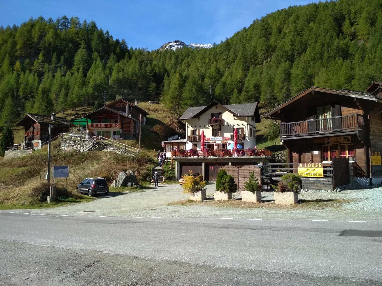 A mountain lodge with a balcony, a restaurant, and a sign for 'A LOUER'.