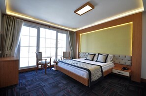 Deluxe kamer | Een minibar, een kluis op de kamer, een bureau, geluiddichte muren