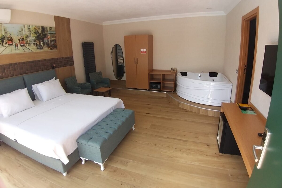 Habitación de hotel con cama, zona de estar, sauna y televisor.