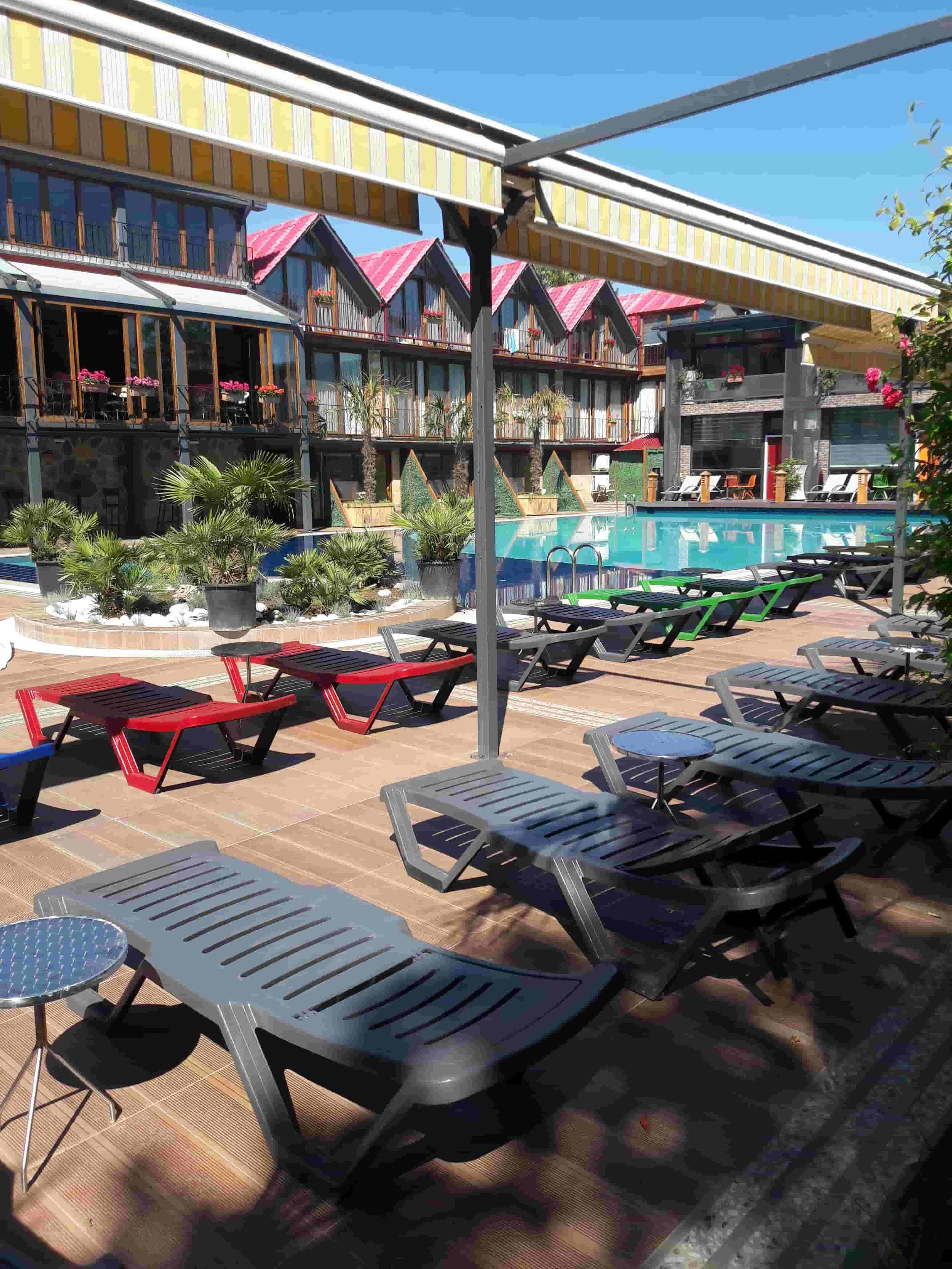 A hotel with outdoor seating and a pool area.