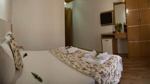 A bedroom with a bed, a desk, and a wardrobe. - Portofino Hotel (Ula)