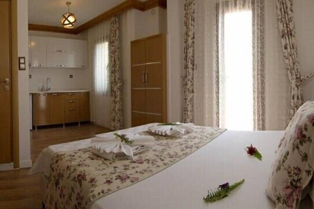 Una camera d'albergo con un letto, un angolo cottura e un bagno.