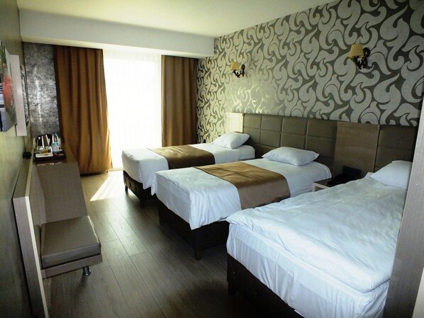 A hotel room with two beds, a desk, and a chair. - Colonia Park Hotel (Sebinkarahisar)