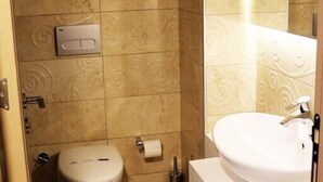 A bathroom with a toilet, sink, and towel rack. - Colonia Park Hotel (Sebinkarahisar)