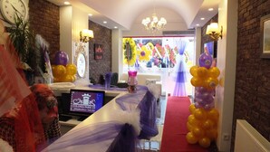A hotel lobby with a reception desk, a chandelier, a clock, and a brick wall. - Colonia Park Hotel (Sebinkarahisar)