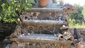 A tiered stone structure with pottery and shells.