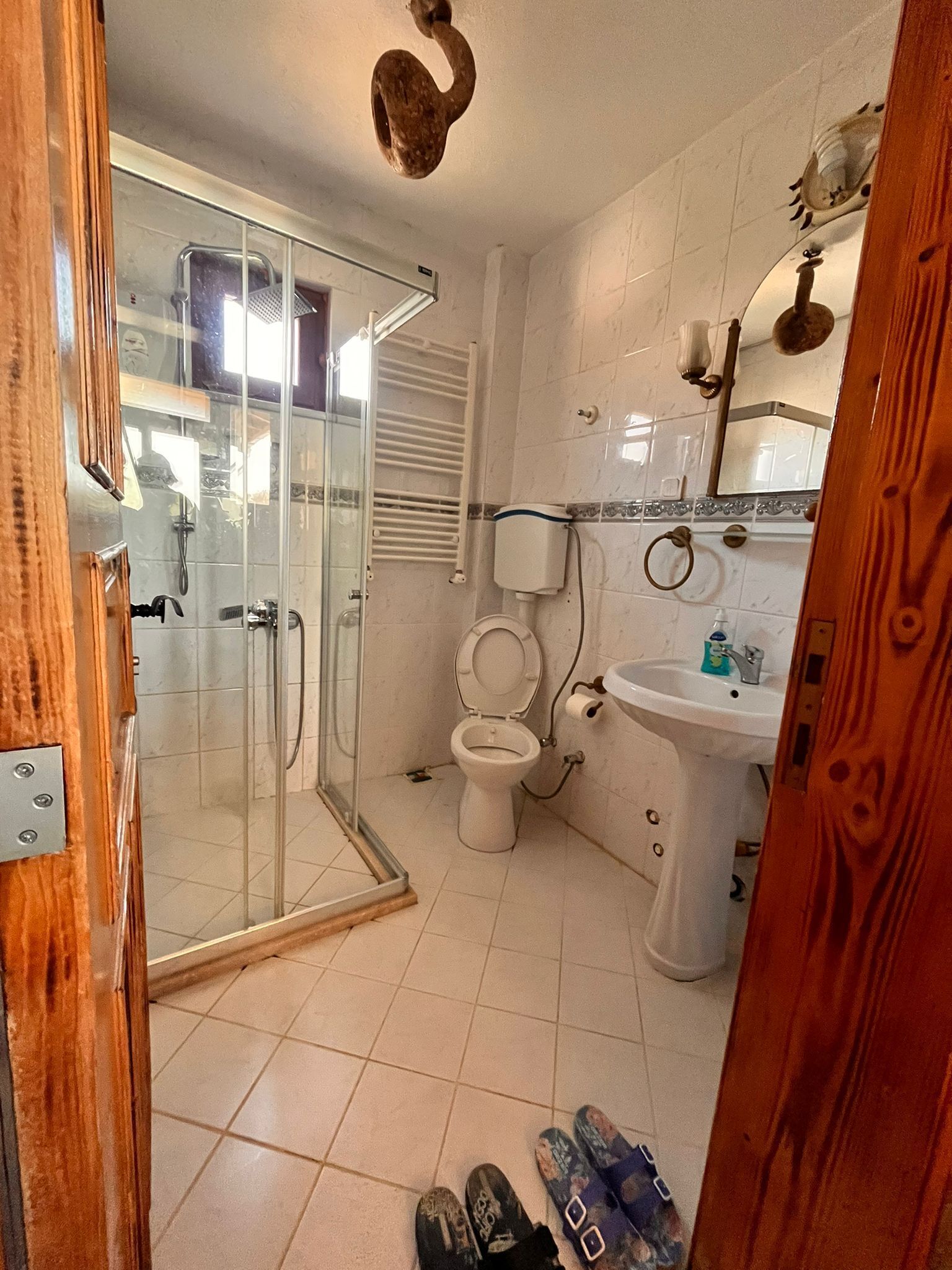 Une salle de bain avec une douche à parois de verre, des toilettes, un lavabo et un miroir.