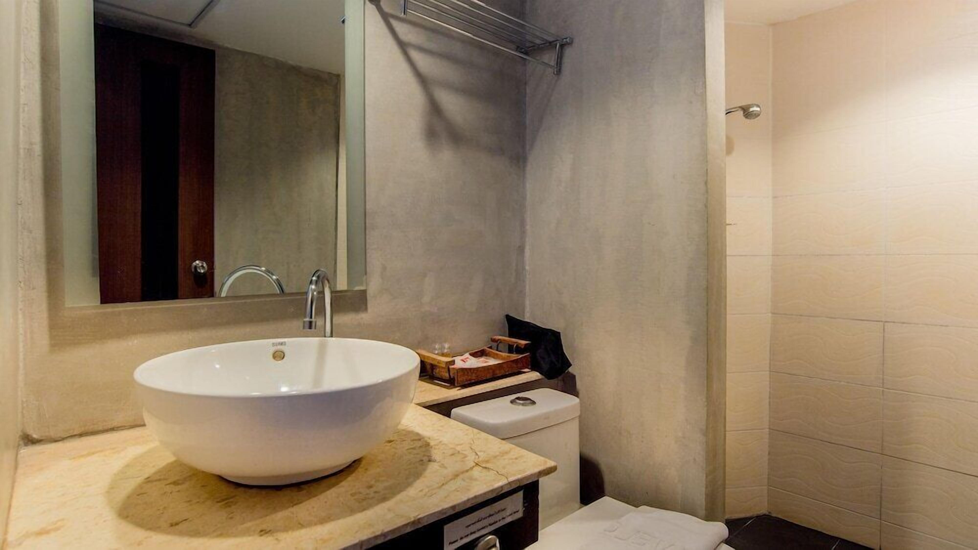 Een badkamer met een groot wit wastafelmeubel, een spiegel, een handdoek en een douchehoek.