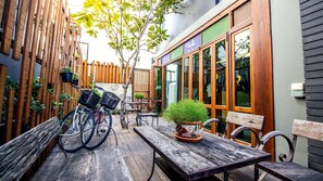 A wooden deck with a table and chairs, a bicycle, and a potted plant. - B2 Nimman Premier Hotel (Chiang Mai)