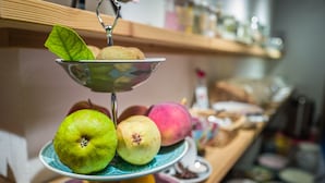 A fruit display with apples and oranges on a table.