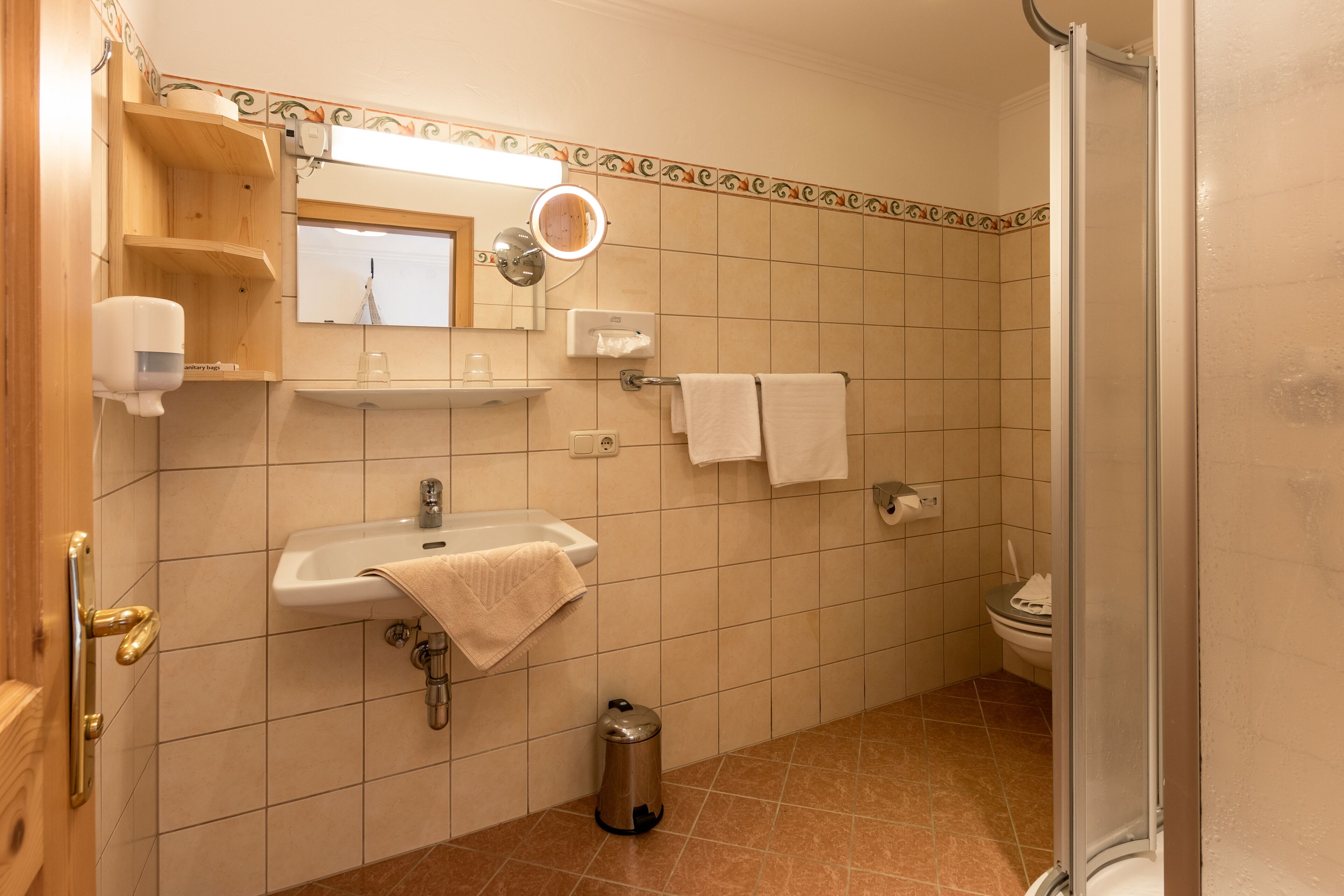 A bathroom with a sink, mirror, towel rack, and toilet.