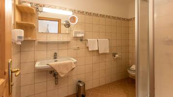 A bathroom with a sink, mirror, towel rack, and toilet.