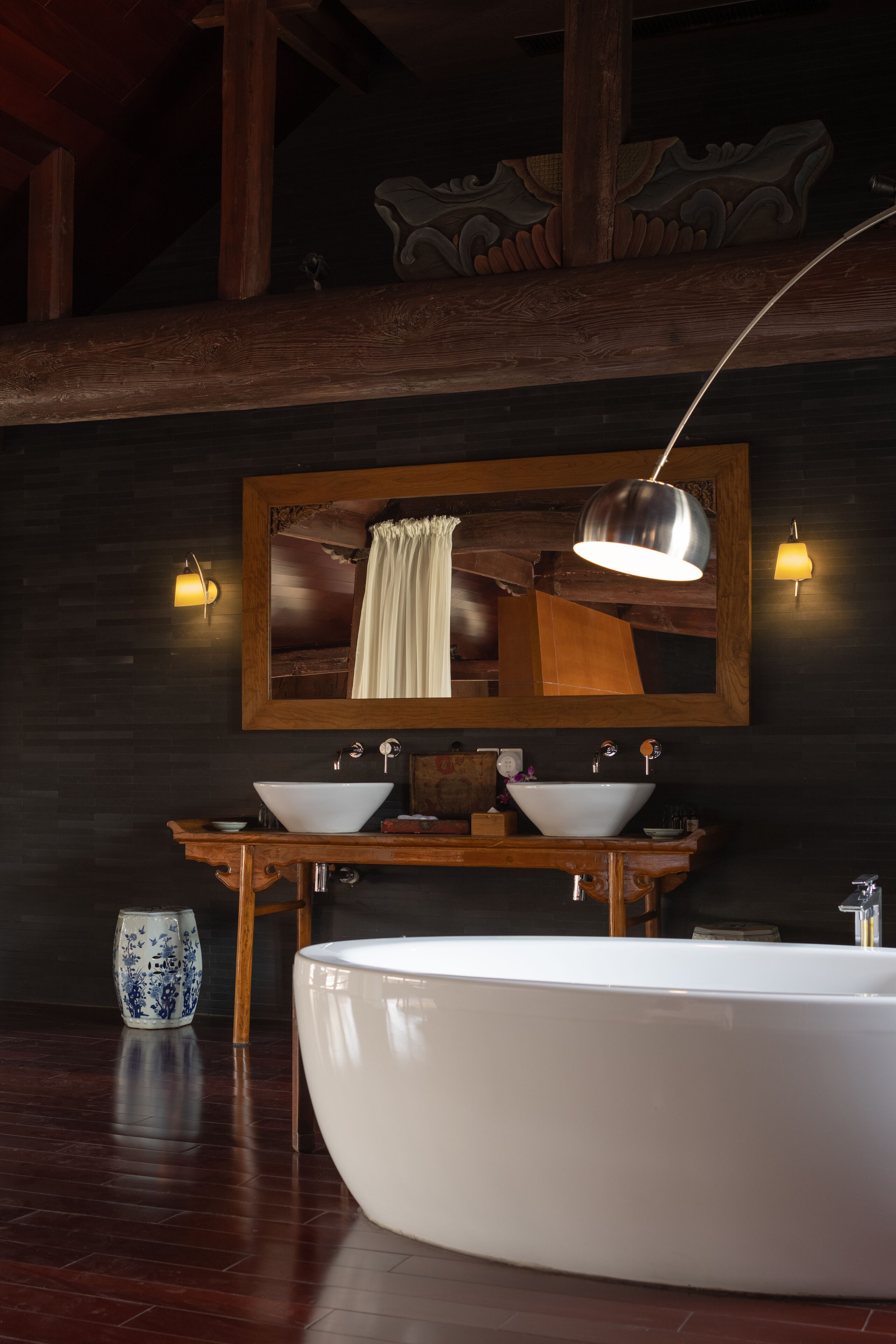 A modern bathroom with a freestanding bathtub, a double sink vanity, and a large mirror above the vanity.