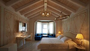 Ein Schlafzimmer mit einem großen Bett, einem Schreibtisch, einer Couch und einem Fernseher.