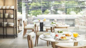 A modern dining area with round tables, chairs, and a glass partition. - KritThai Residence (Bangkok)