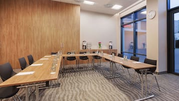A conference room with a long table, chairs, and a clock on the wall.
