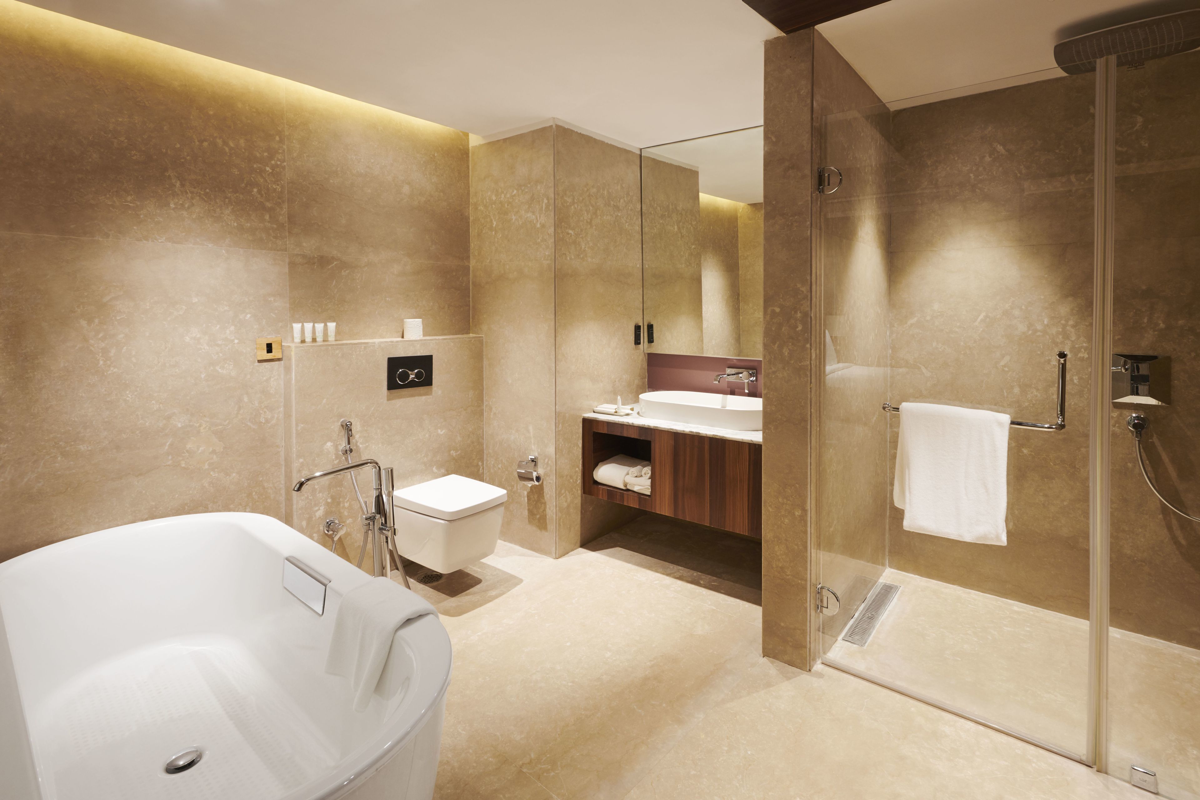 A modern bathroom with a freestanding bathtub, a glass-enclosed shower, and a vanity with a mirror.