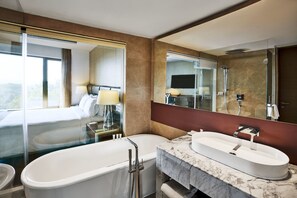 Ein modernes Badezimmer mit einer großen Badewanne, einem separaten Waschbecken und einer Dusche.
